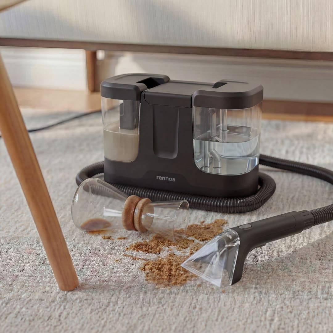 Rennoa SpotCleaner under et bord ved siden af spildt müsli fra en væltet glaskrukke på tæppet